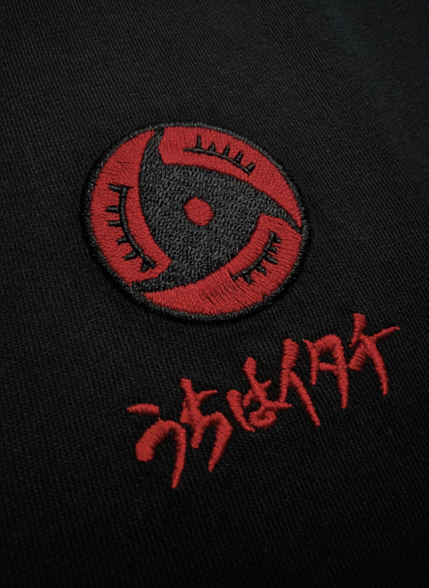 Zoom broderie fine Mangekyou Sharingan et calligraphie japonaise Itachi – T-Shirt Naruto Shippuden™ PROJO